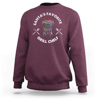 Maroon crewneck sweatshirt with BBQ chef graphic and “Santa’s Favorite Grill Chef” text.