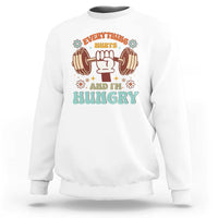 White sweatshirt with "Everything Hurts and I'm Hungry" dumbbell graphic.