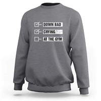 Charcoal gray crewneck sweatshirt with “DOWN BAD,” “CRYING,” “AT THE GYM” text graphic on back