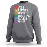 Charcoal gray crewneck sweatshirt with colorful “LATS GLUTES BICEPS TRICEPS QUADS” graphic
