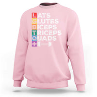 Light pink crewneck sweatshirt with colorful “LATS GLUTES BICEPS TRICEPS QUADS” graphic