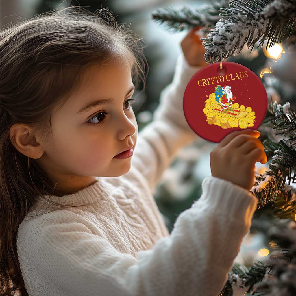 Red round 'CRYPTO CLAUS' ornament with Santa and gold coin sleigh, hanging on evergreen