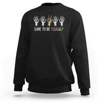 Black crewneck sweatshirt with skeleton-hand rainbow graphic and "DARE TO BE YOURSELF"