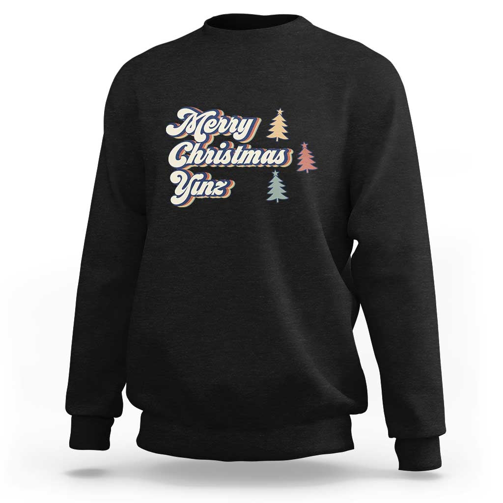 Black crewneck sweatshirt with “Merry Christmas Yinz” holiday graphic and pine trees