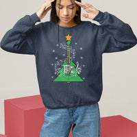 Navy crewneck sweatshirt on model with hands raised; green guitar-themed Christmas tree graphic