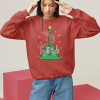 Red crewneck sweatshirt on model with hands raised; green guitar-themed Christmas tree graphic
