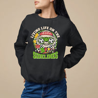 Black crewneck sweatshirt with soccer-themed 'Sidelines' graphic on chest
