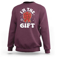 Maroon unisex Christmas sweatshirt with 'I'm the gift' graphic and red bow illustration