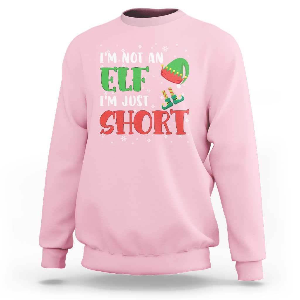 Light pink crewneck sweatshirt with elf graphic and text "I'm not an elf, I'm just short"