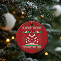 Red round Christmas ornament hanging from pine branches, showing Christmas tree graphic