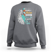 Charcoal sweatshirt with nurse quote graphic and angel wing print on front.