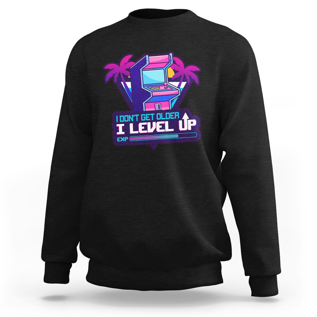 Black crewneck sweatshirt with colorful gaming console graphic and Level Up slogan