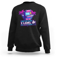 Black crewneck sweatshirt with colorful gaming console graphic and Level Up slogan