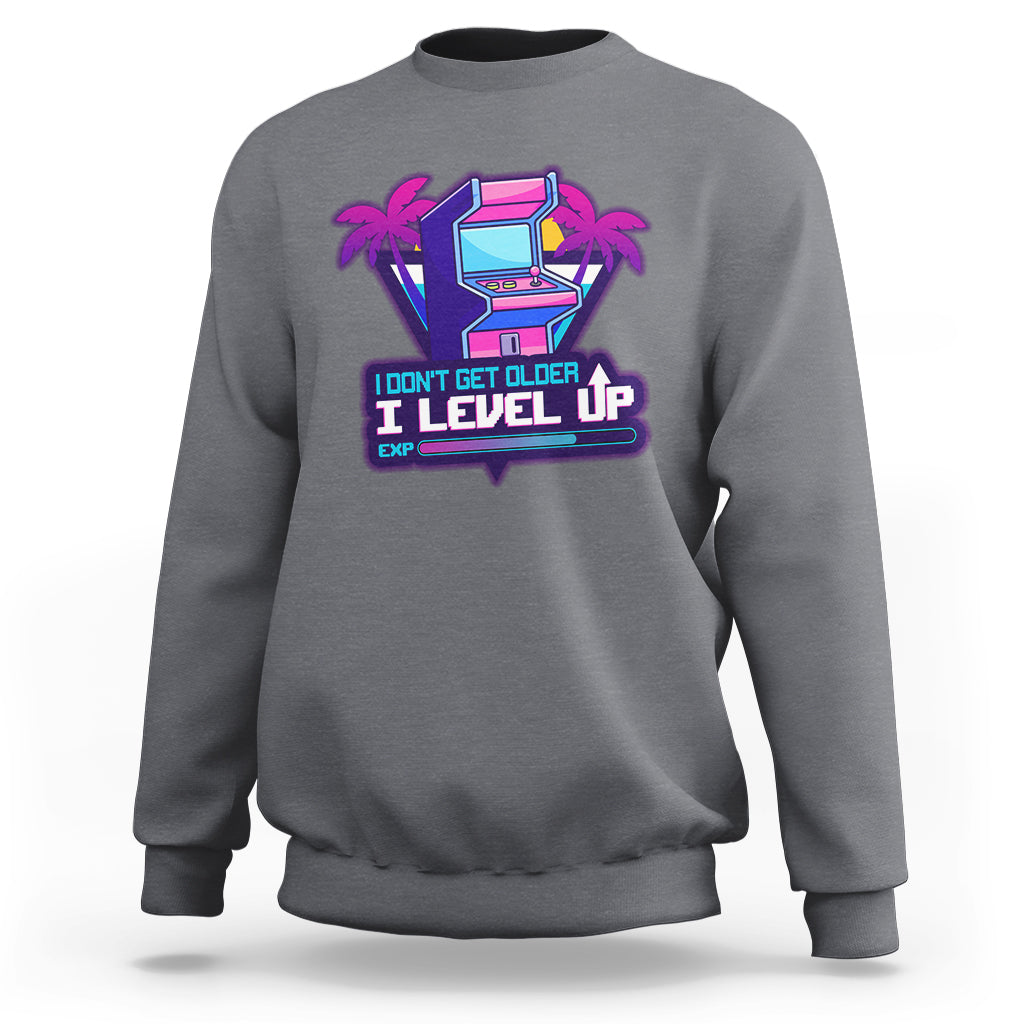 Charcoal gray crewneck sweatshirt with colorful gaming console graphic and Level Up slogan