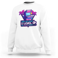 White crewneck sweatshirt with colorful gaming console graphic and Level Up slogan