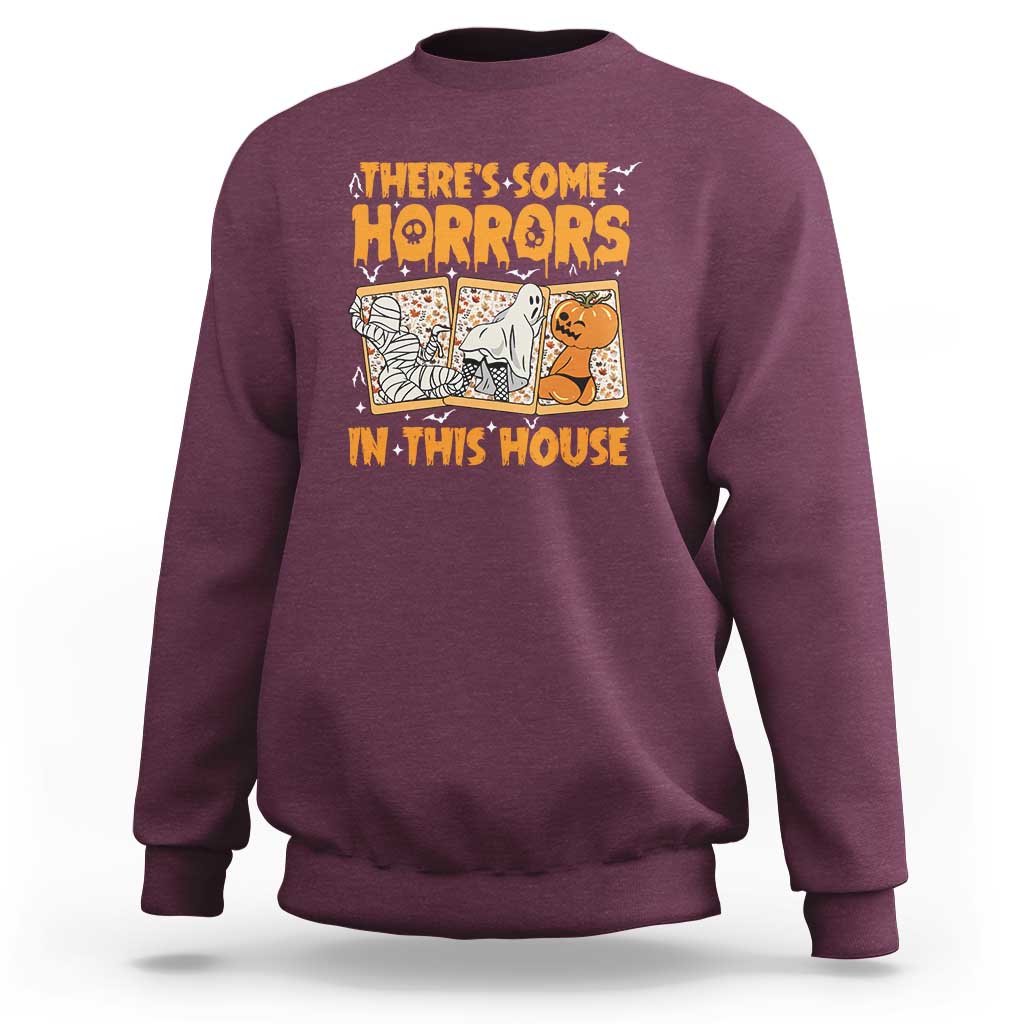 Funny Halloween sweatshirt in maroon, with “There’s Some Horrors In This House” graphic.