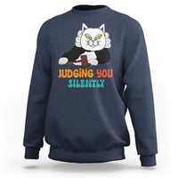 Navy sweatshirt with cat graphic and “JUDGING YOU” “SILENTLY” text on front.