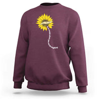 Maroon sweatshirt with yellow sunflower graphic and motivational vertical text on back