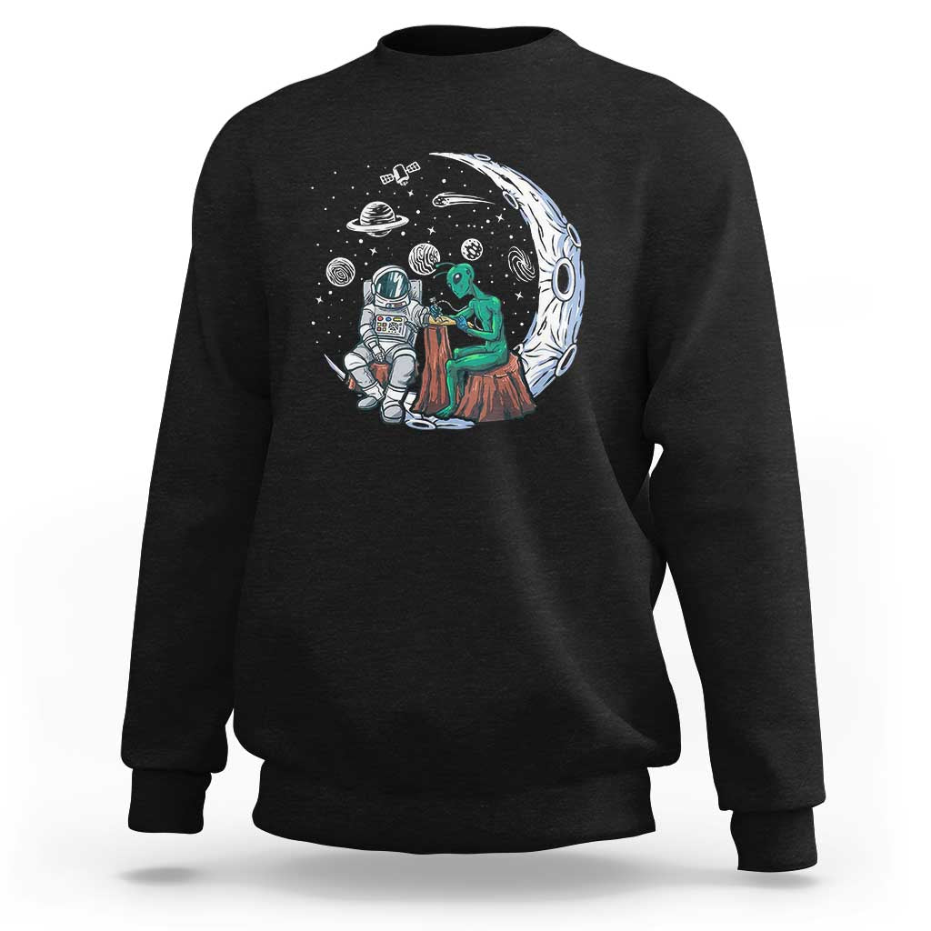 Black sweatshirt with space-themed alien astronaut graphic on the front