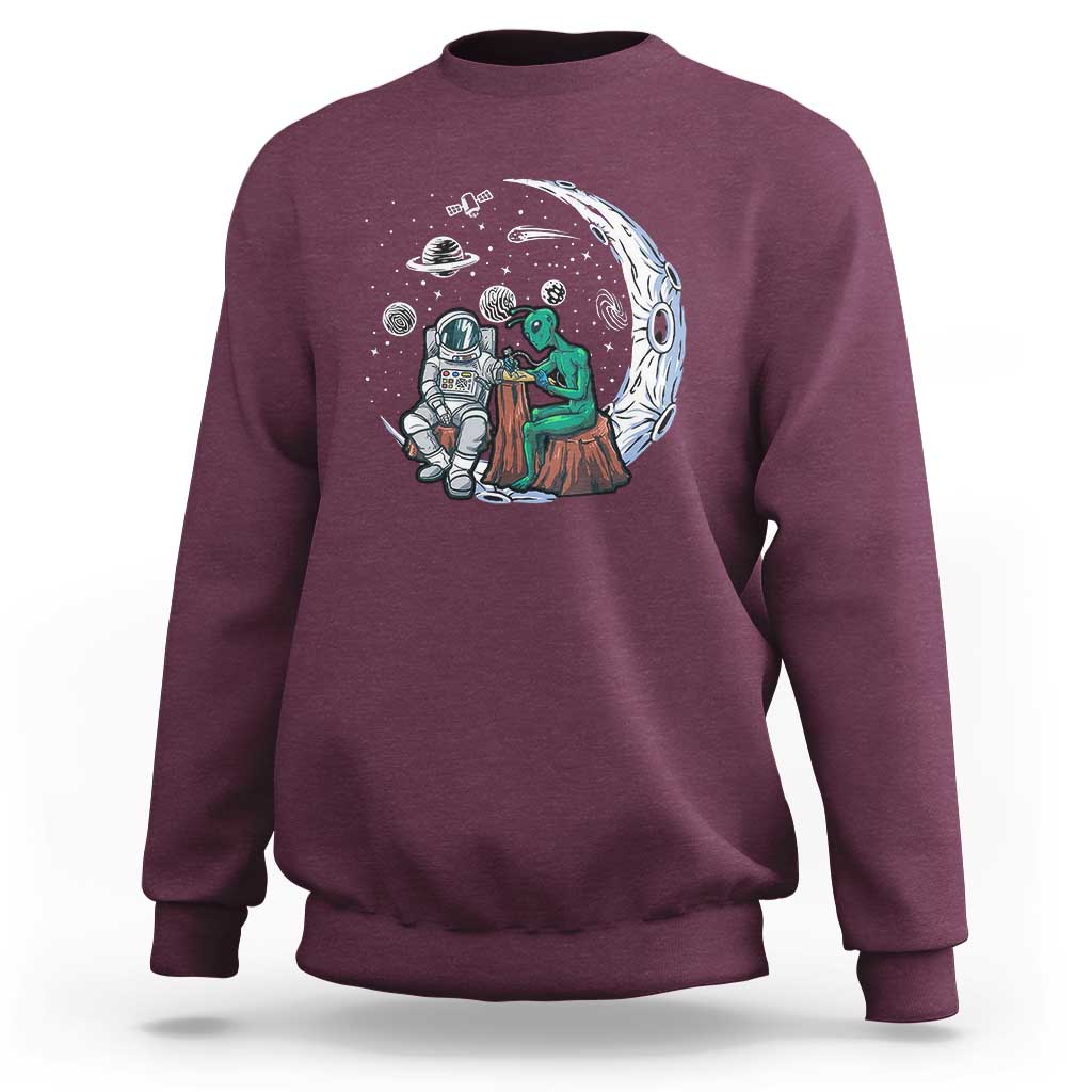 Maroon sweatshirt with space-themed alien astronaut graphic on the front