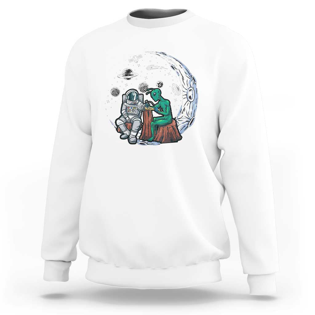 White sweatshirt with space-themed alien astronaut graphic on the front