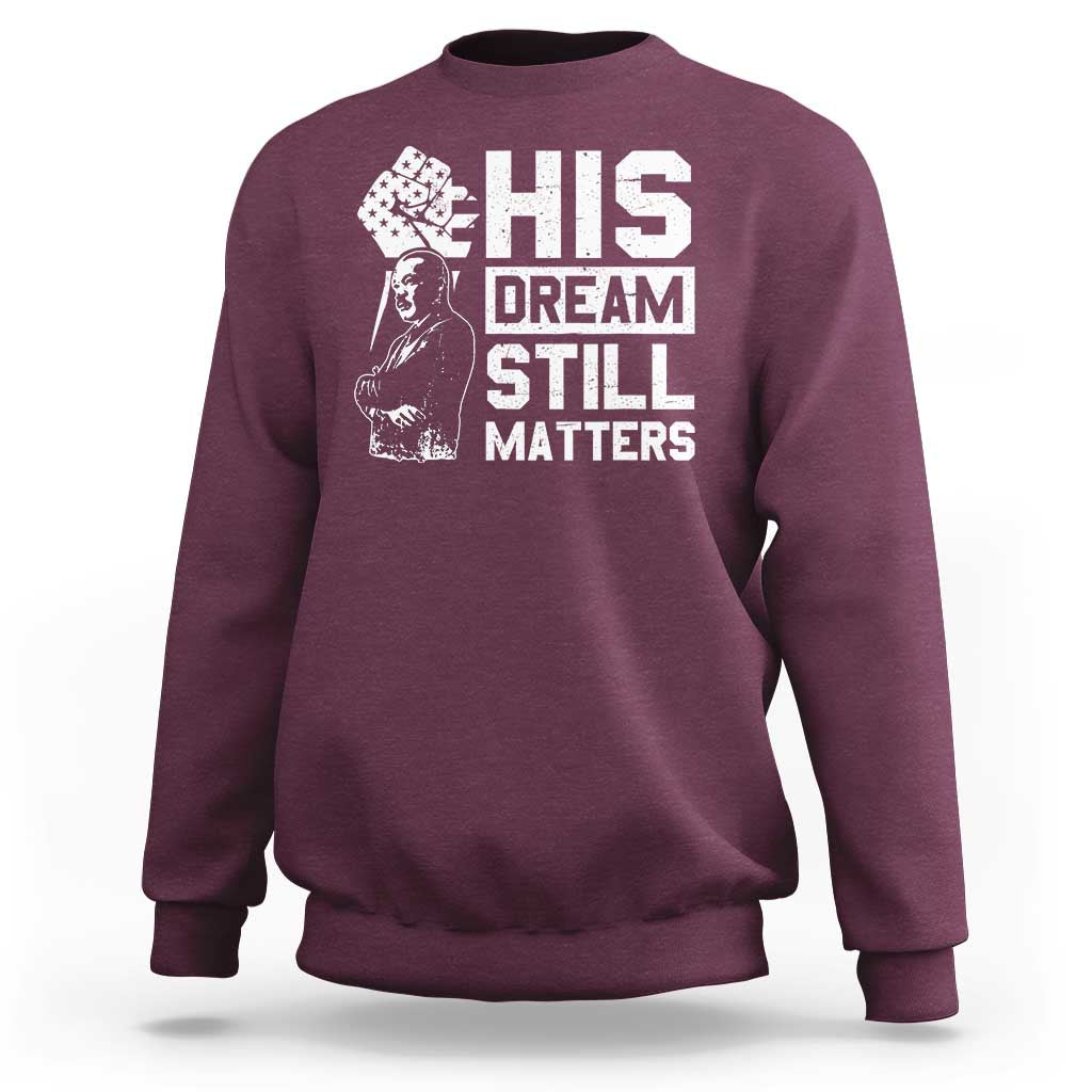 Maroon crewneck sweatshirt with white "HIS DREAM STILL MATTERS" graphic front.