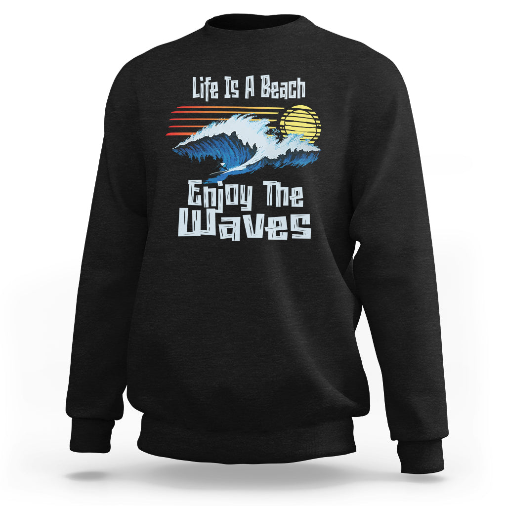 Black crewneck sweatshirt with beach wave graphic and “Enjoy The Waves” text