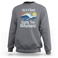 Charcoal crewneck sweatshirt with beach wave graphic and “Enjoy The Waves” text