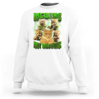 White sweatshirt with cat meme graphic reading 'MEWING NOT MEOWING' in neon green