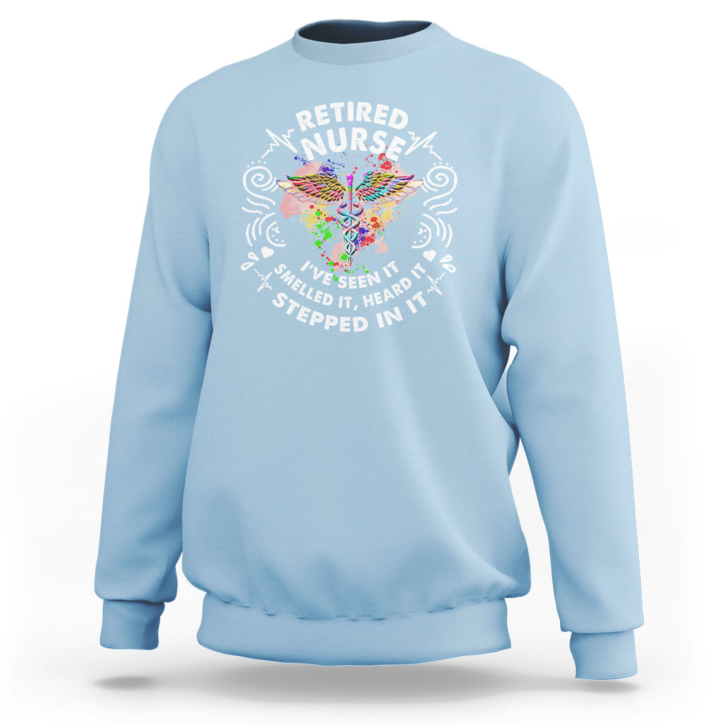 Light blue retired nurse crewneck sweatshirt with colorful graphic text at center