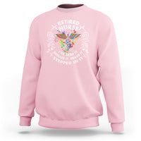 Light pink retired nurse crewneck sweatshirt with colorful nurse graphic and slogan