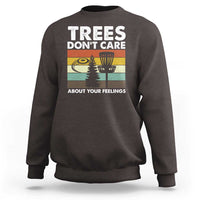 Dark brown crewneck sweatshirt with “Trees don’t care” graphic and trees scene.
