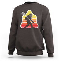 Dark brown crewneck sweatshirt with Bigfoot lacrosse player graphic on chest
