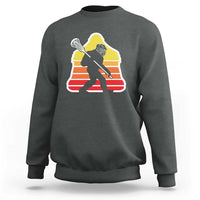 Charcoal crewneck sweatshirt with Bigfoot lacrosse player graphic, centered