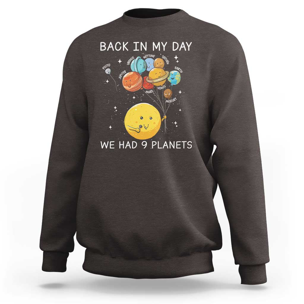 Dark brown crewneck sweatshirt with space planets graphic and 'We Had 9 Planets' text.