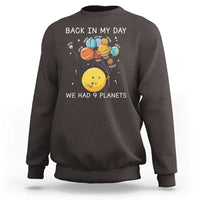 Dark brown crewneck sweatshirt with space planets graphic and 'We Had 9 Planets' text.
