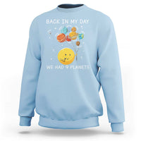 Light blue crewneck sweatshirt with space planets graphic and 'We Had 9 Planets' wording.
