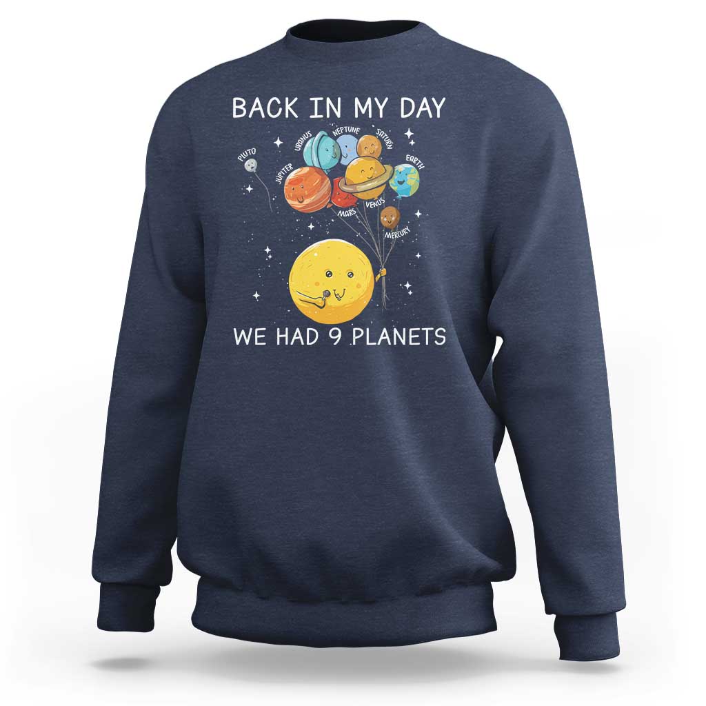 Dark blue crewneck sweatshirt with space planets graphic and text 'We Had 9 Planets'.
