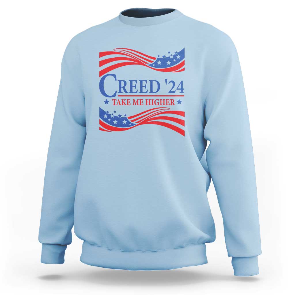 Light blue crewneck sweatshirt with patriotic “Creed '24” graphic and wavy flag print