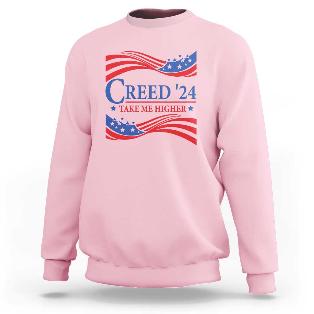 Light pink crewneck sweatshirt with patriotic “Creed '24” graphic and wavy flag print