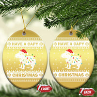 Gold oval capybara Christmas ornament pair with “HAVE A CAPY” and “CHRISTMAS”