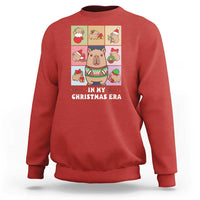 Red Christmas sweatshirt with capybara graphic and “IN MY CHRISTMAS ERA” text.