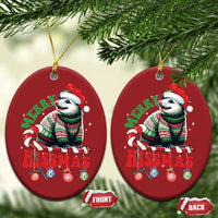 Two red oval opossum Christmas ornaments hanging on pine branches