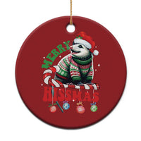 Red round Christmas ornament with a cartoon opossum wearing a Santa hat and scarf