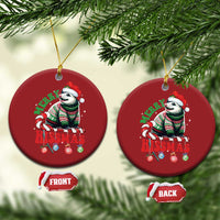 Pair of red round opossum Christmas ornaments hanging on a tree branch