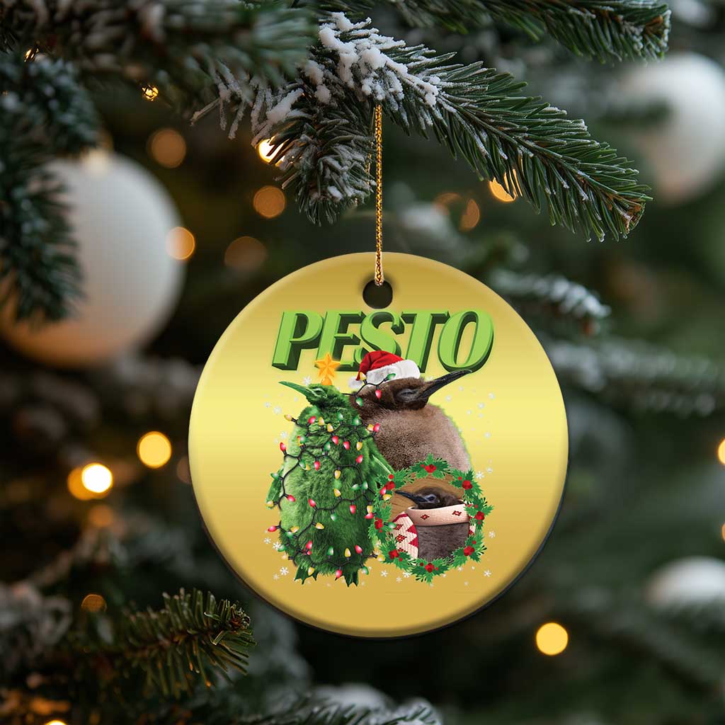 Gold circle Christmas ornament with PESTO text, penguin, decorated wreath, and gift