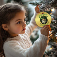 Gold round Christmas ornament with green leprechaun portrait hanging from a tree