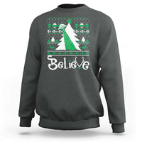 Charcoal crewneck sweatshirt with festive 'Believe' print and green bow UFO graphic