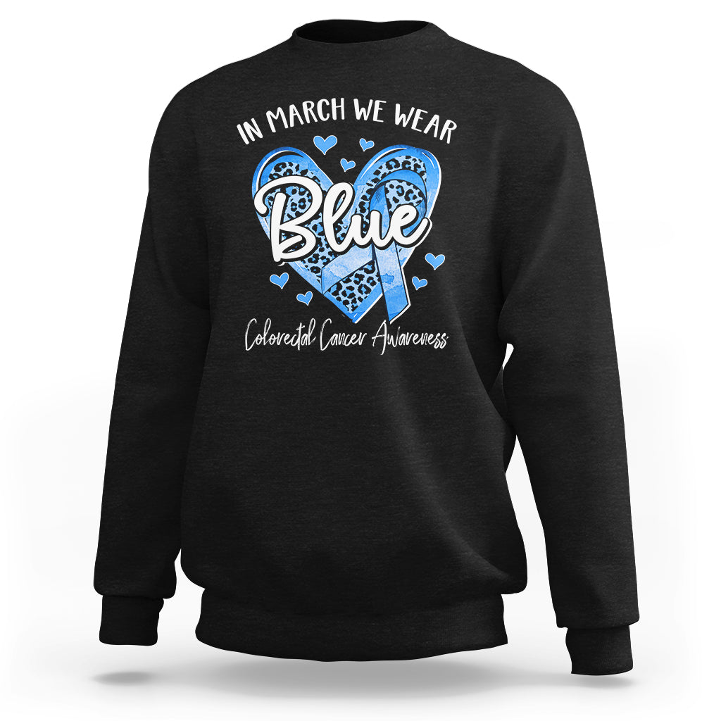 Black crewneck sweatshirt with “In March We Wear Blue” graphic and blue heart design