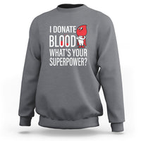 Charcoal gray crewneck sweatshirt with front print: “I Donate Blood What’s Your Superpower?”